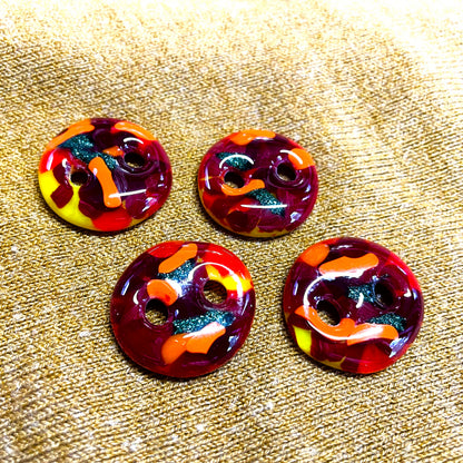 Front view of four handmade red fused glass buttons