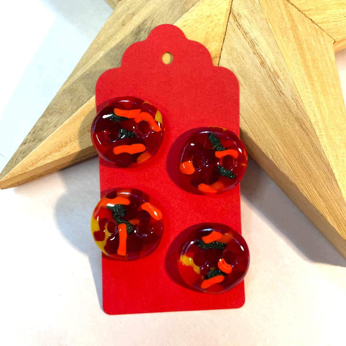 Set of four red fused glass buttons with orange, yellow and sparkly green glass details