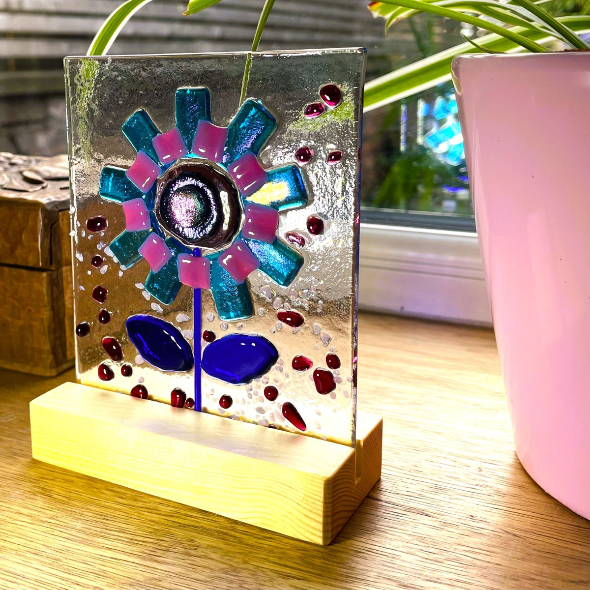 Freestanding turquoise and pink fused glass flower panel in a pine base