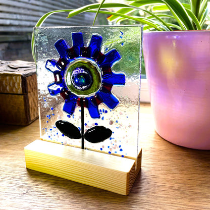 Close-up of cobalt-blue and red glass petals with a green and blue centre