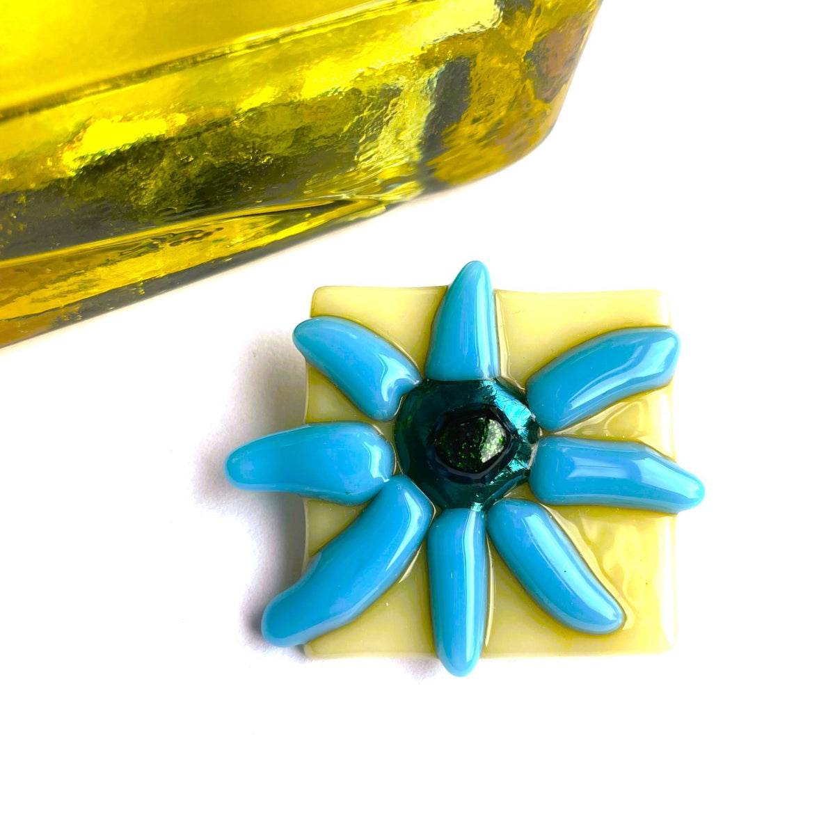 Back of a warm vanilla and blue flower fused glass brooch showing the secure brooch fitting
