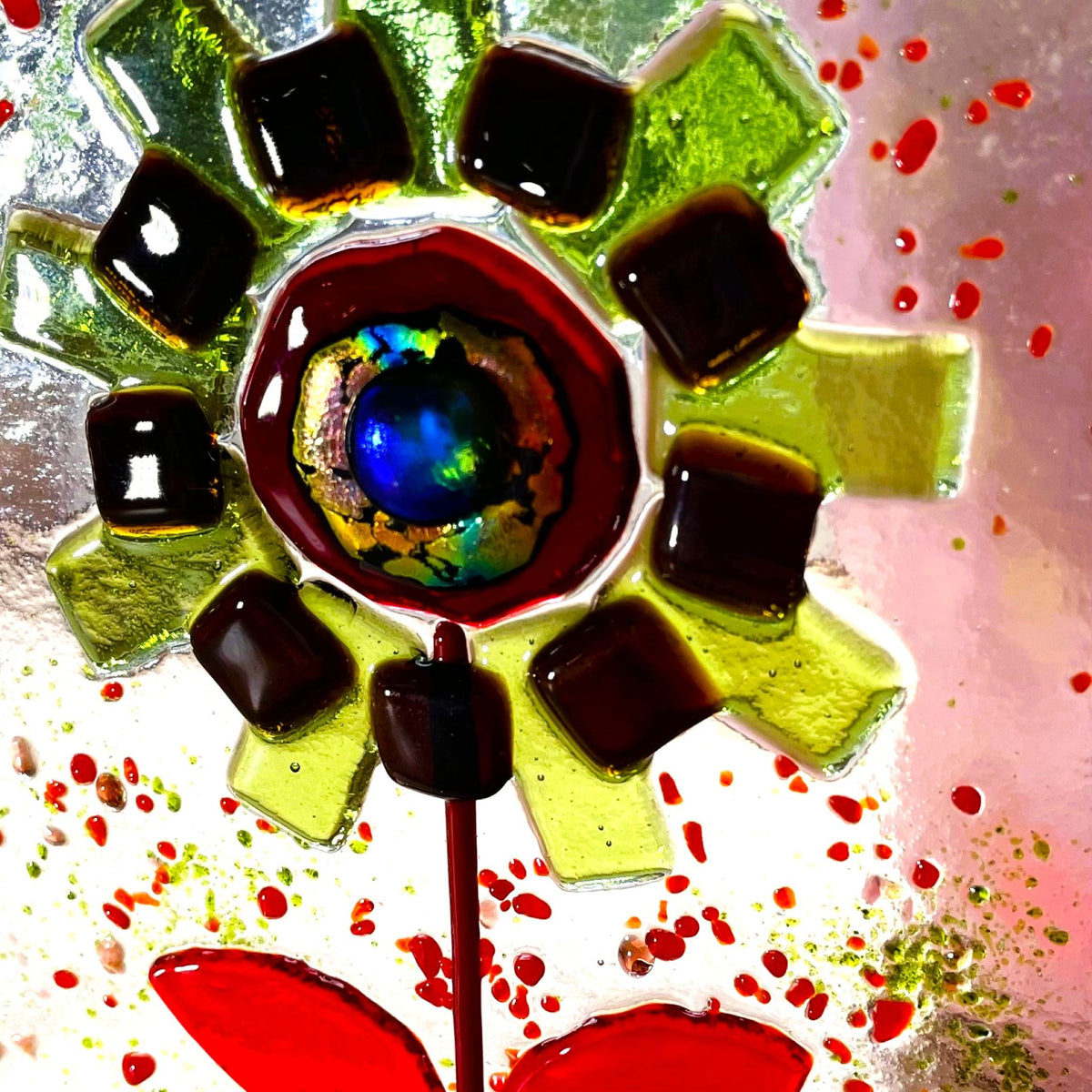 Green and red fused glass flower suncatcher standing in a pine base
