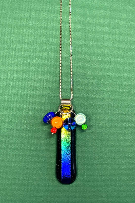 A slice of Rainbow fused glass pendant with added beads