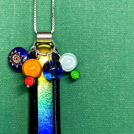 A slice of Rainbow fused glass pendant with added beads
