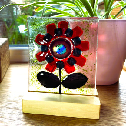 Close-up of the blue-green iridescent centre in a red fused glass flower