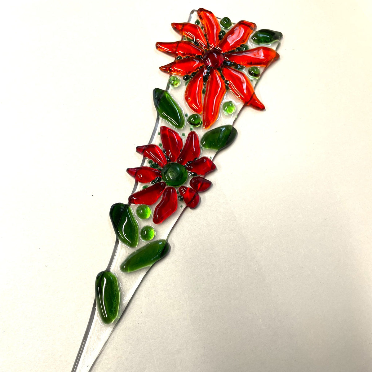 Red fused-glass flower plant stake displayed in a plant pot