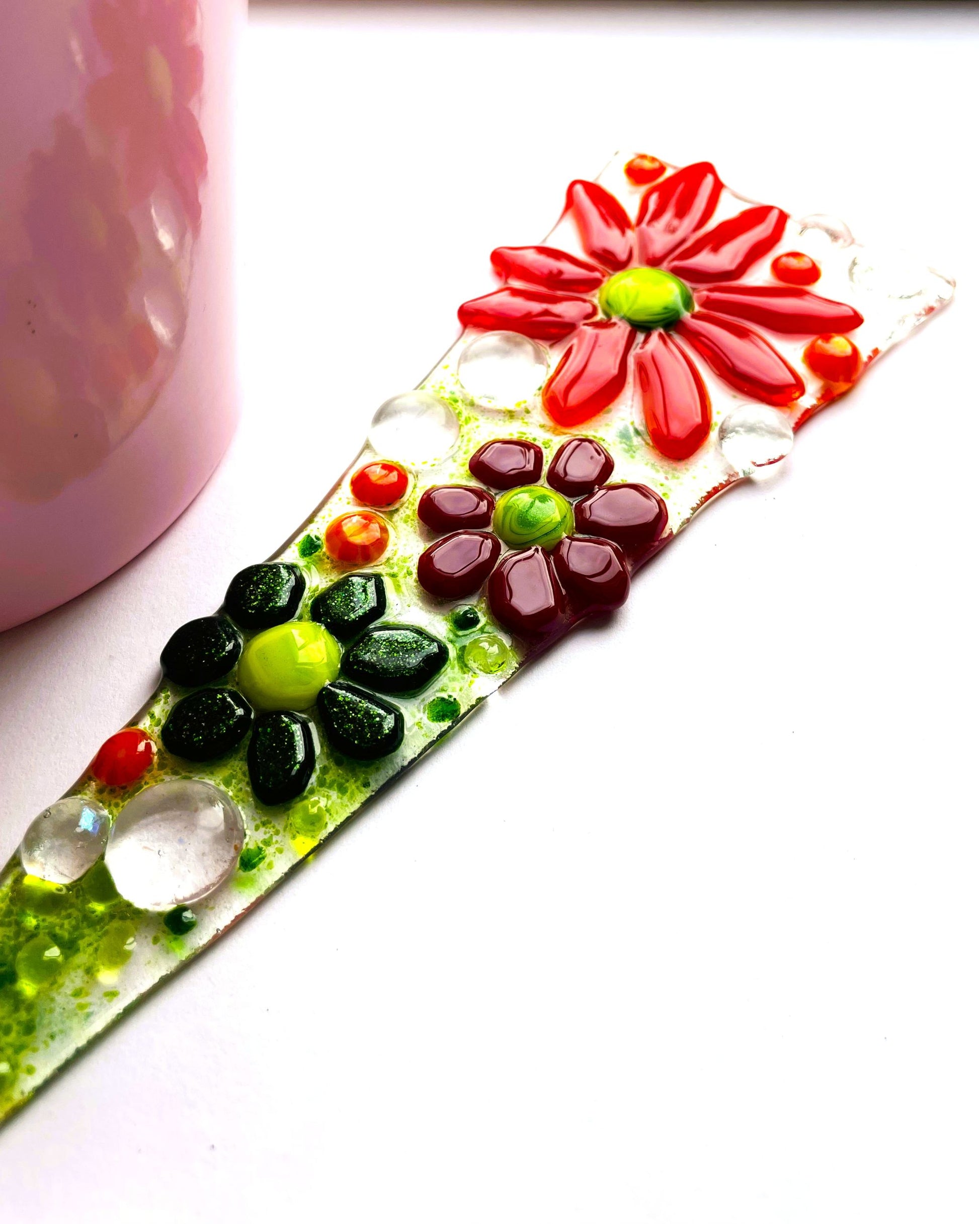 Red glass flower plant stake in outdoor plant pot