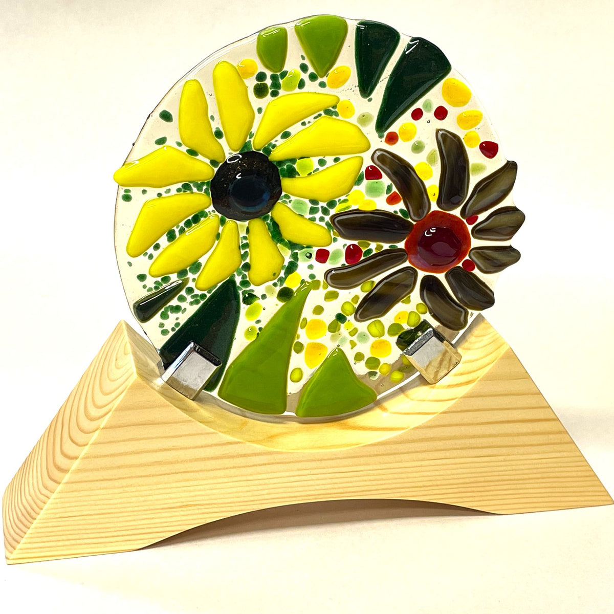 Summer garden fused-glass roundel glowing in sunlight on its wooden base