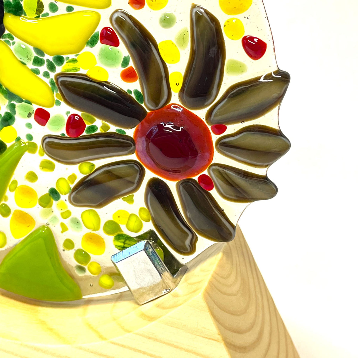Colourful fused-glass garden roundel displayed on a wooden base